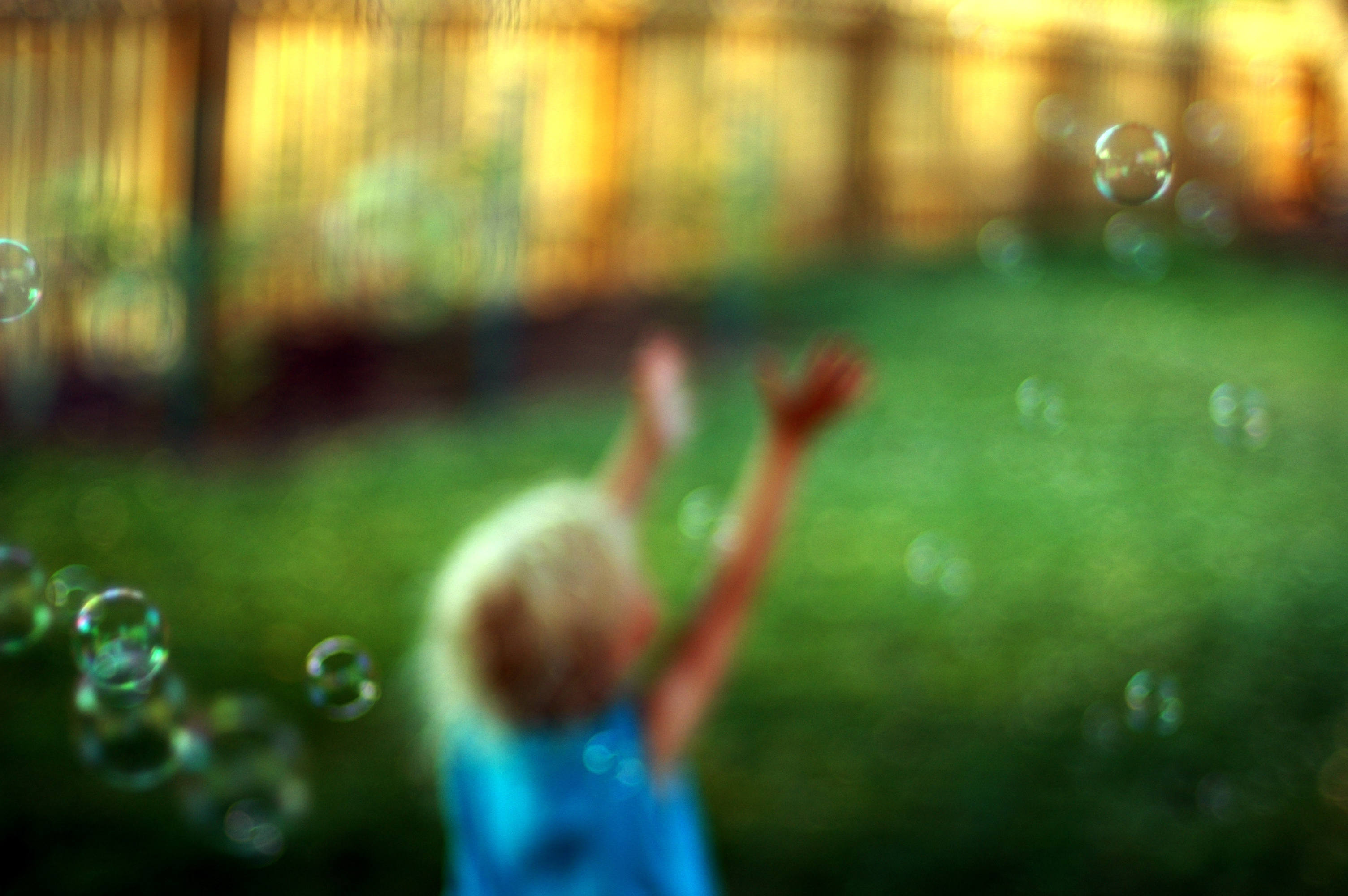 blurry image of a child catching bubbles