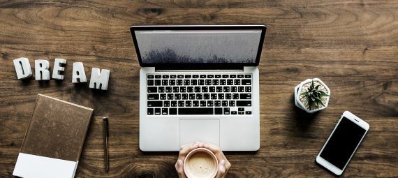 blogging as a living, laptop, mug, plant, phone and book on a desk